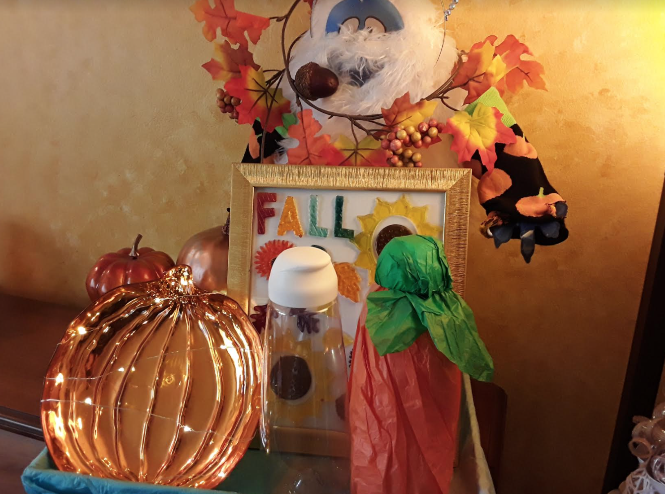 Gold tray withh autumnal items like a tissue paper pumpkin